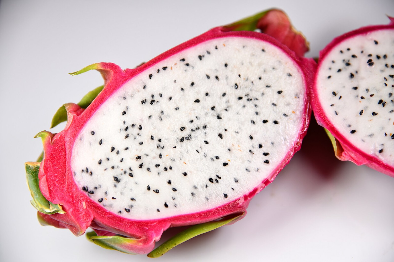 White-flesh dragon fruit halves on a clean light surface.
