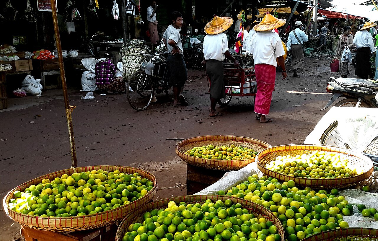 Baskets of green limes at an outdoor market.