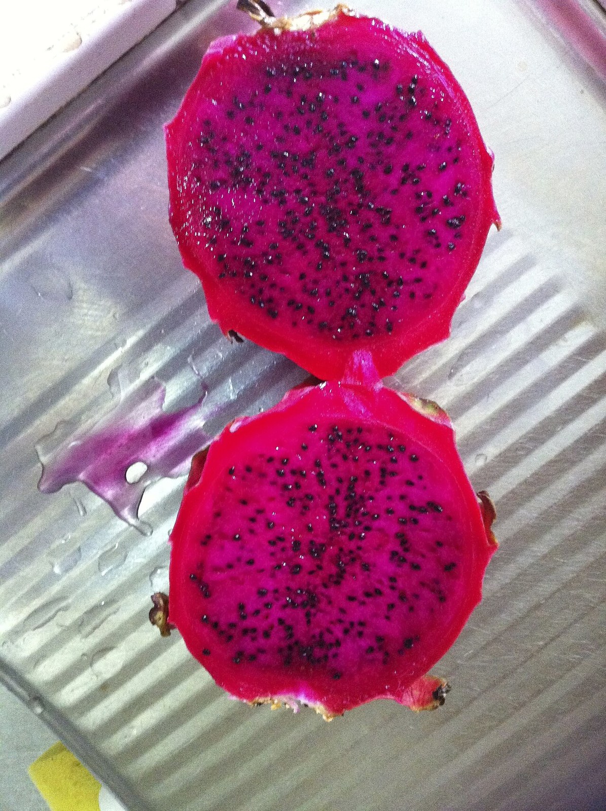 A halved red-flesh dragon fruit showing its vivid interior.