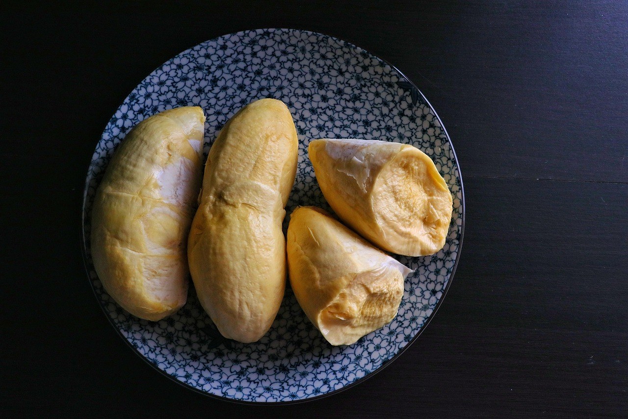 Durian flesh segments on a dark plate.
