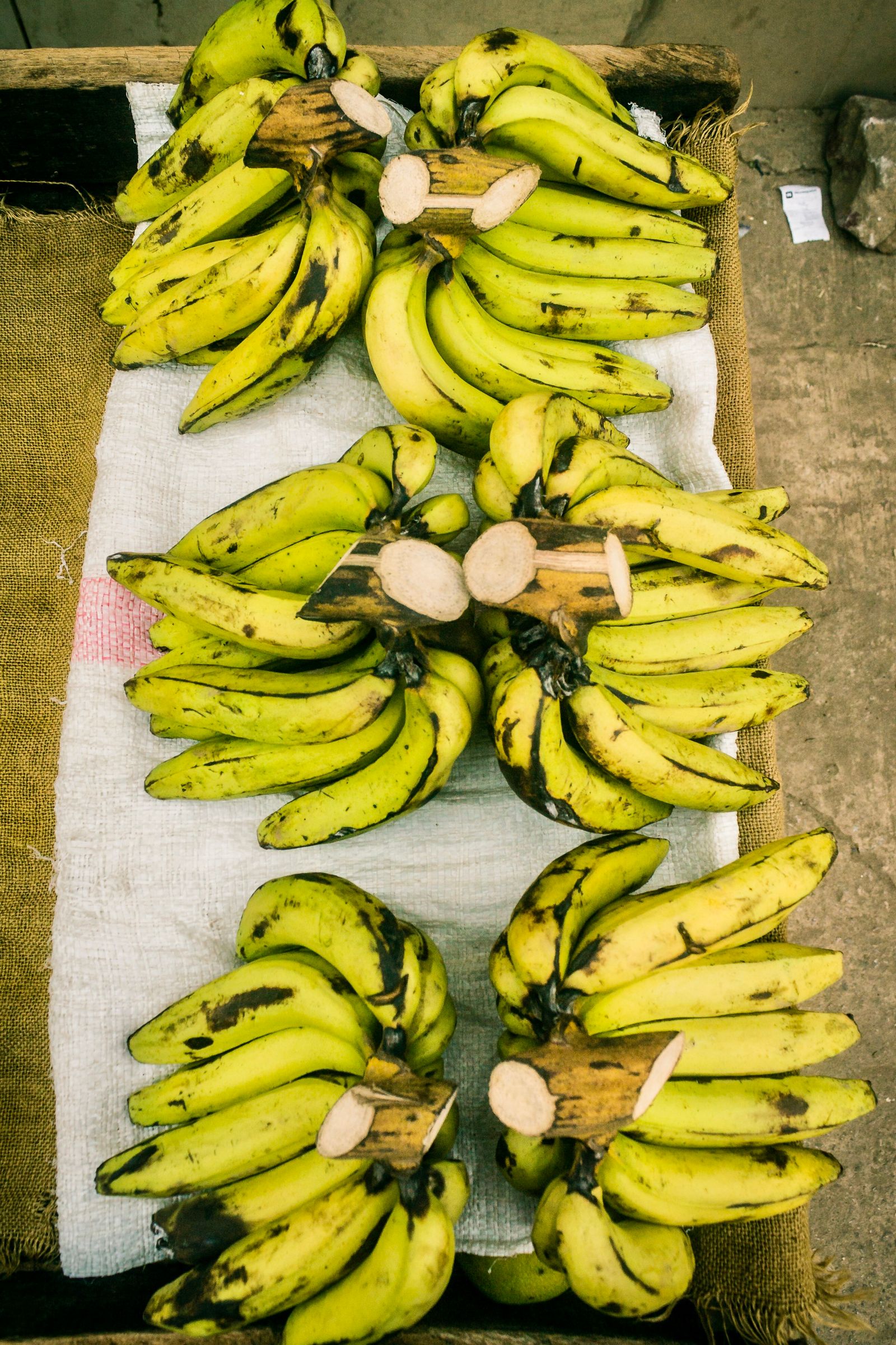 Green banana bunches displayed on a market stall