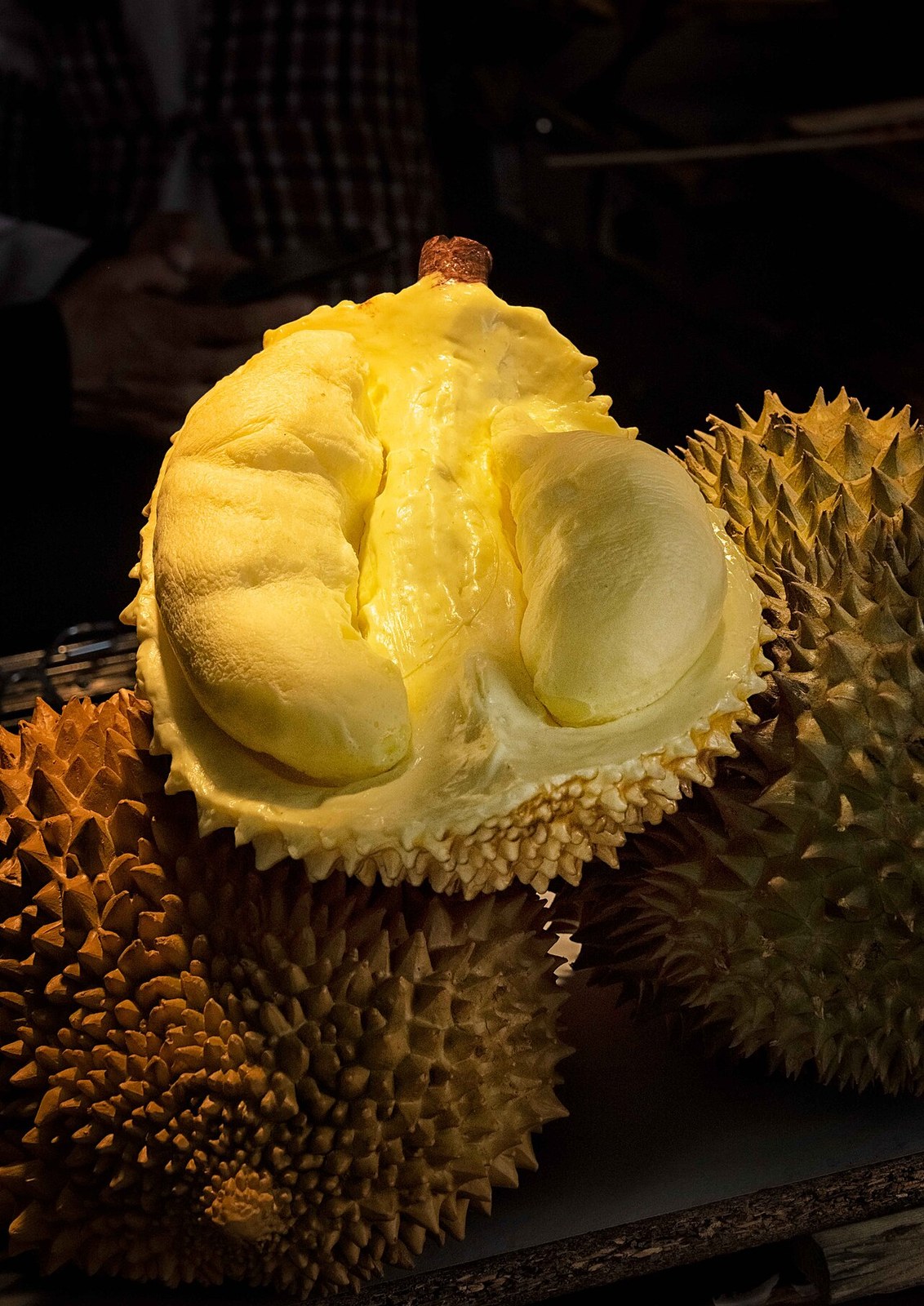 An opened durian showing yellow flesh.