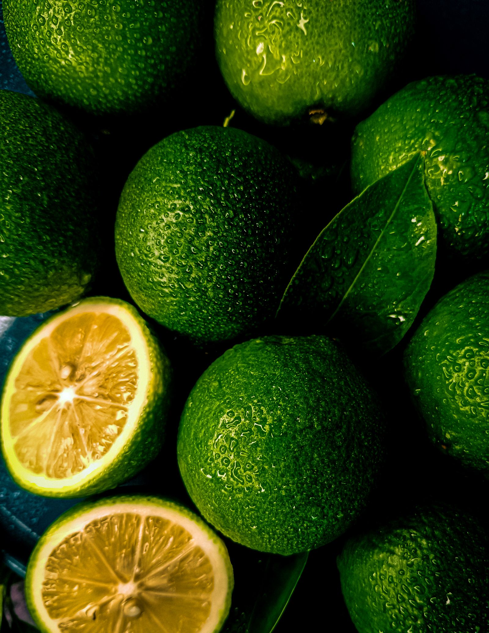Green limes photographed in close-up with water droplets
