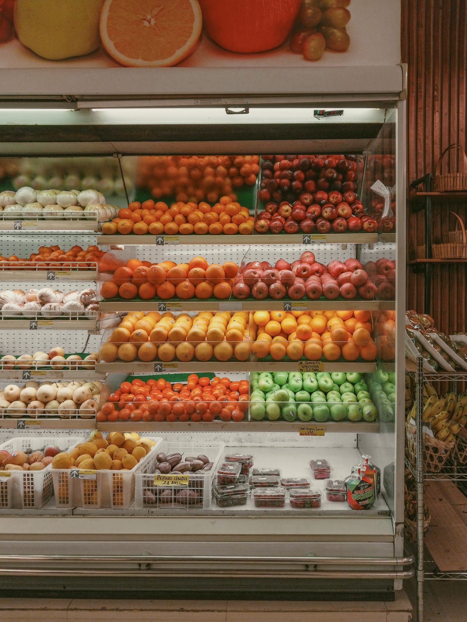 Assorted fruit arranged in a refrigerated retail display