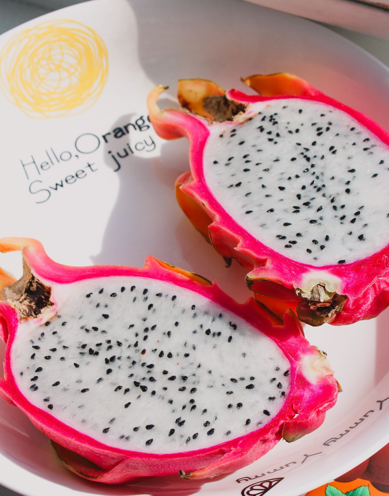 Halved white-flesh dragon fruit with black seeds.