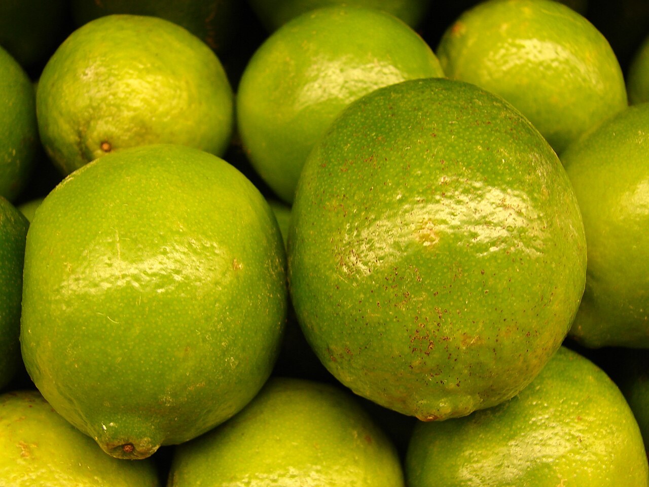 Whole Persian/Tahitian limes in a market display; source identifies Foodland Pukalani, Maui, Hawaii, USA.