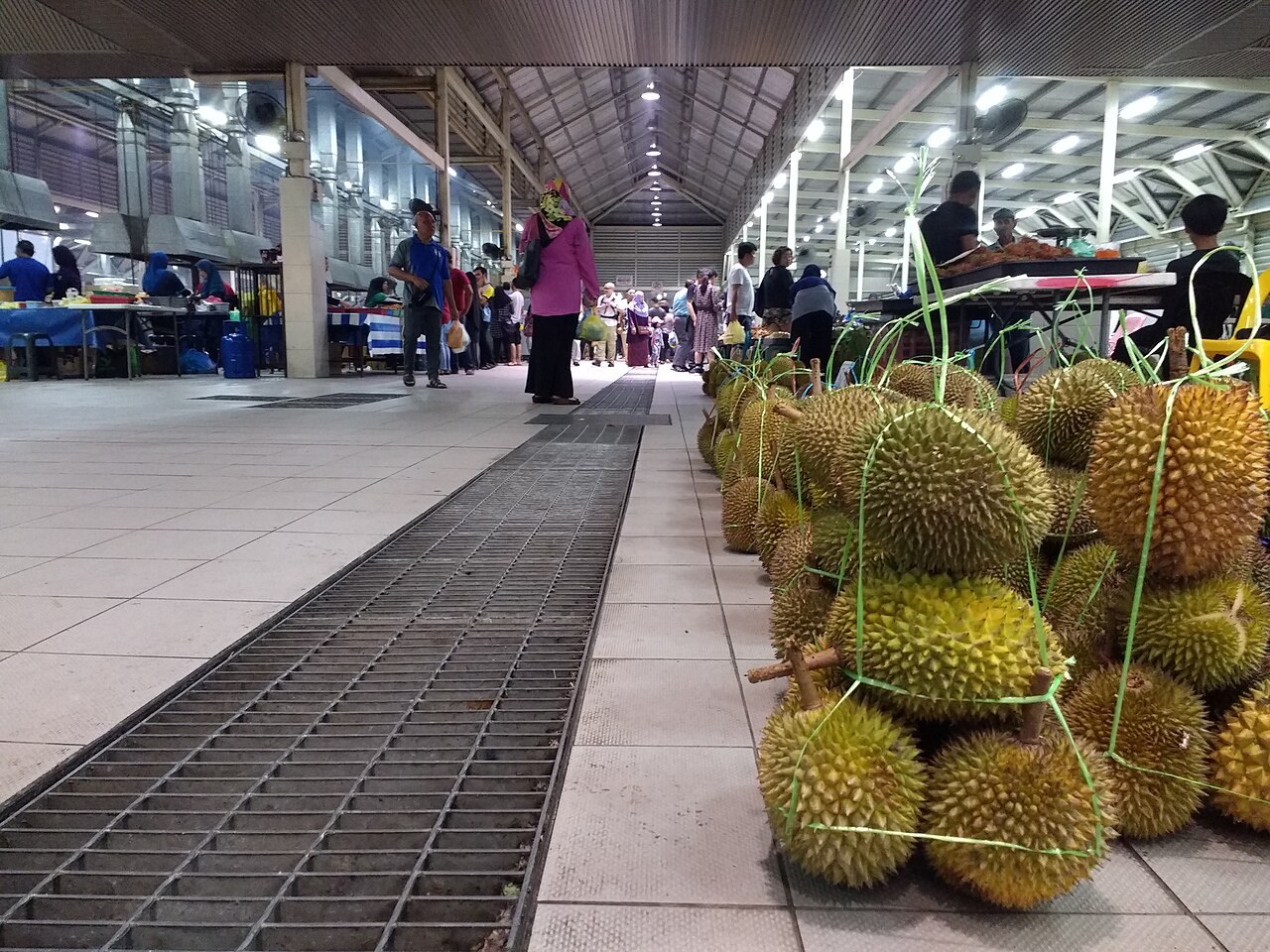 Durian fruits displayed at a covered market.