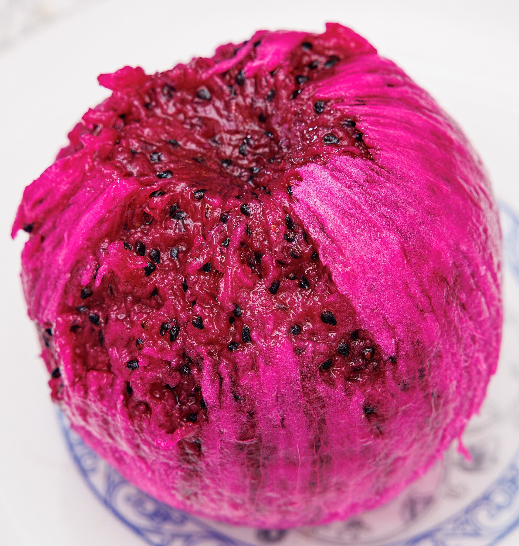 Peeled red dragon fruit flesh in a clear serving bowl.