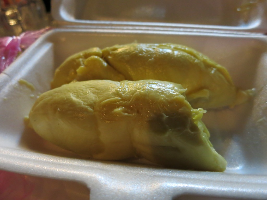 Pale yellow durian flesh in a plain food tray.