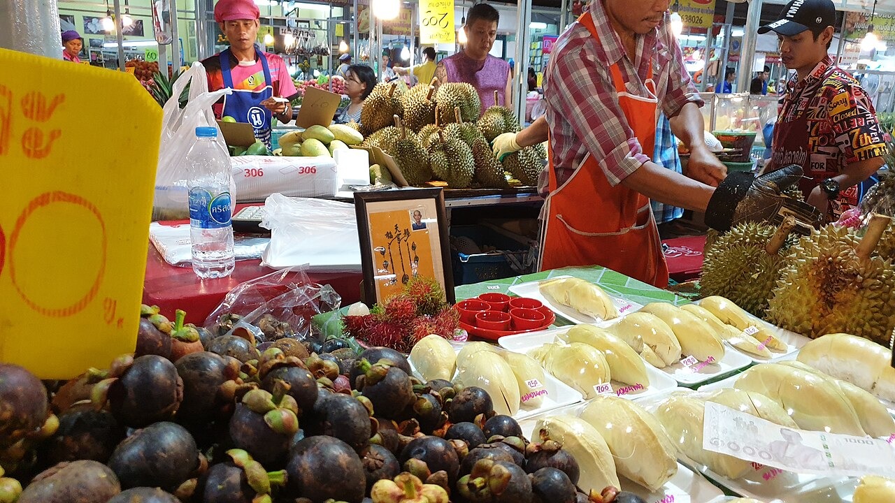 Sầu riêng tươi nguyên trái và trái đã cắt tại quầy hàng ở chợ Bangkok.