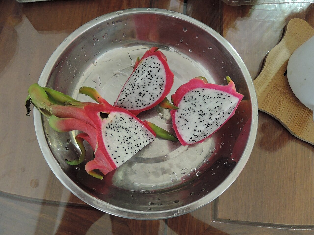White-flesh dragon fruit wedges arranged on a metal plate.