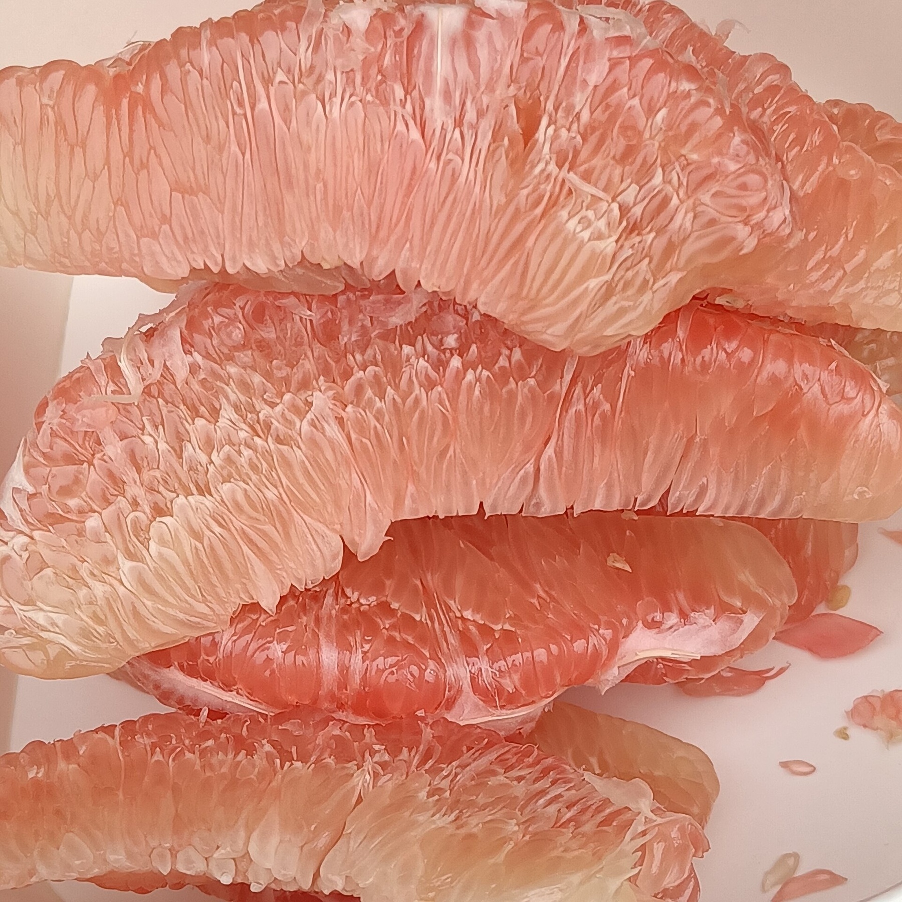 Các múi bưởi hồng đã bóc vỏ, nhìn rõ tép bưởi.