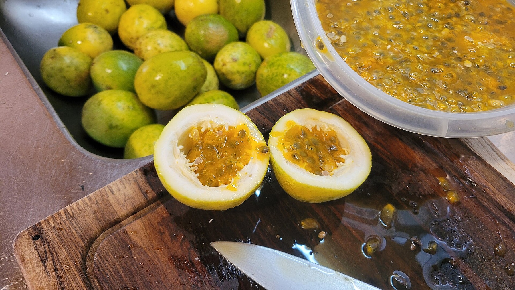Chanh dây vàng bổ đôi bên cạnh phần ruột đã lấy ra trong bát.